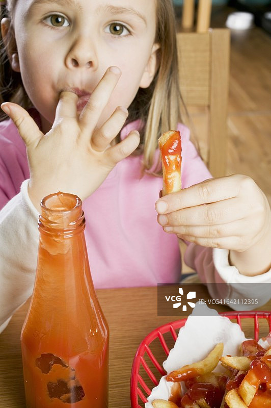 女孩吃薯条和番茄酱图片素材