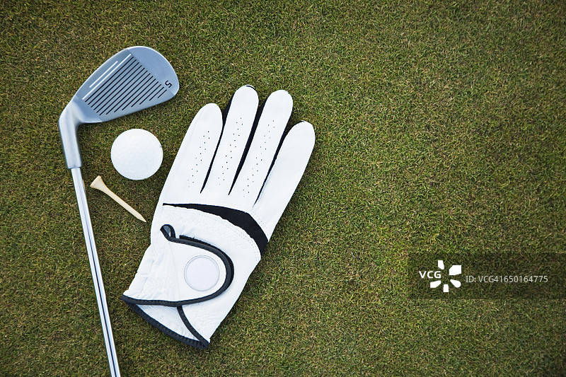 高尔夫球场上使用的高尔夫手套、球杆、球和球座图片素材