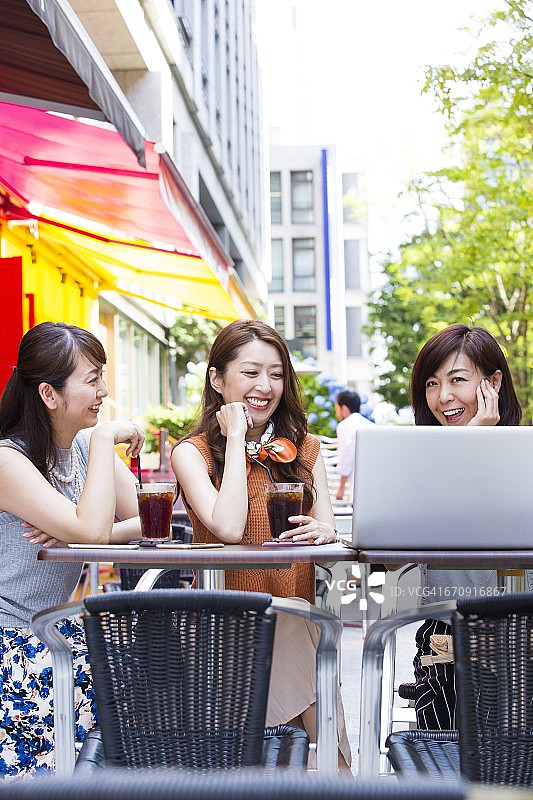 在户外咖啡馆里使用电脑的商业女性图片素材