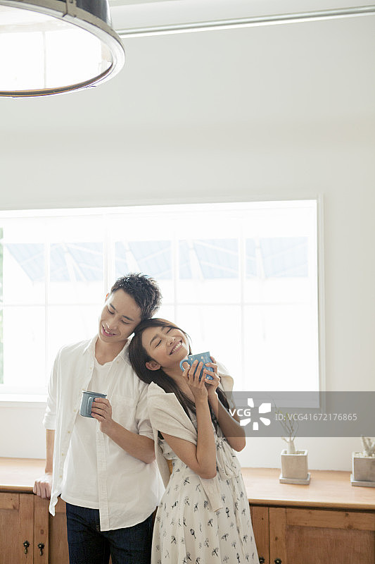 幸福的年轻夫妇正在房间里喝咖啡图片素材