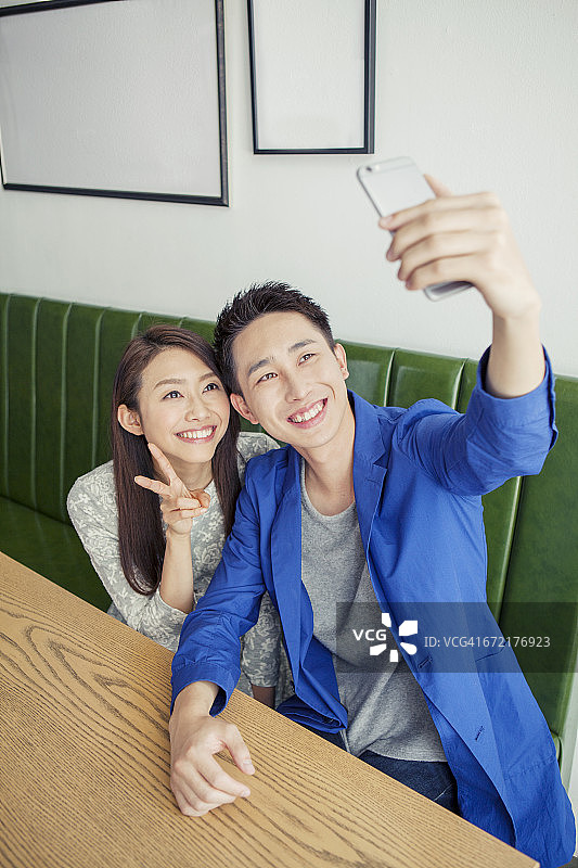 一对年轻情侣在咖啡馆自拍聊天图片素材