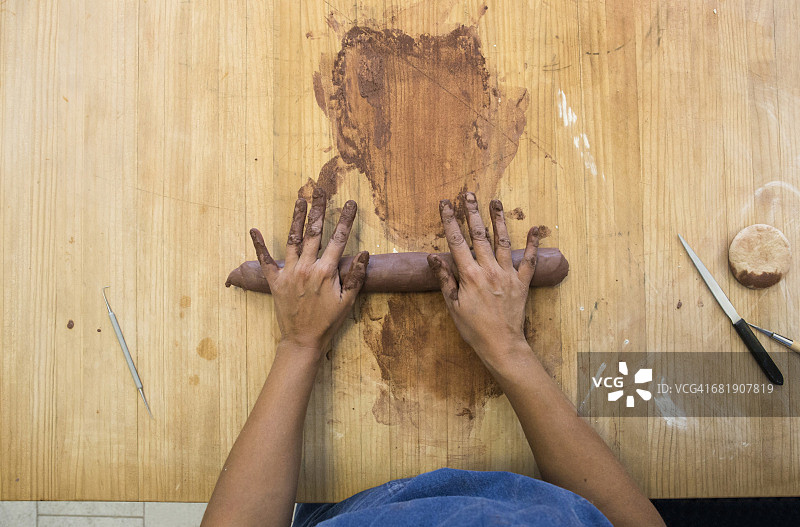 这是一名在陶艺作坊里制作陶土的妇女的双手图片素材
