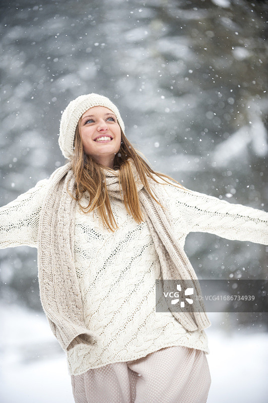 微笑的金发女人在冬天穿着针织品的肖像图片素材
