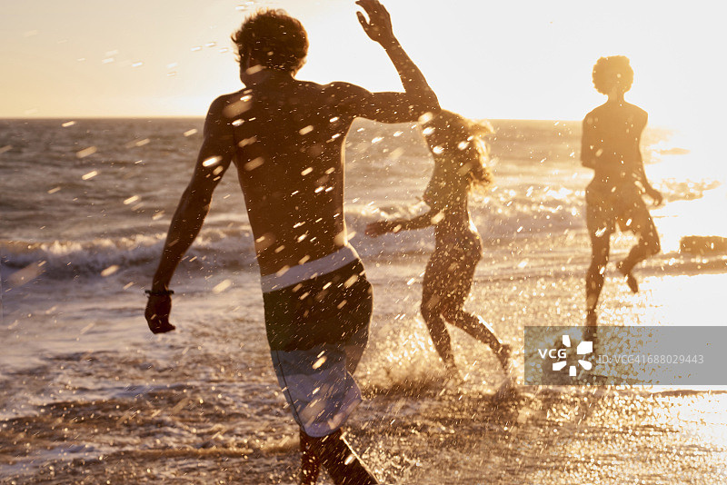 日落时沙滩上嬉戏的朋友图片素材