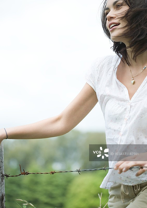 站在篱笆旁的女人图片素材
