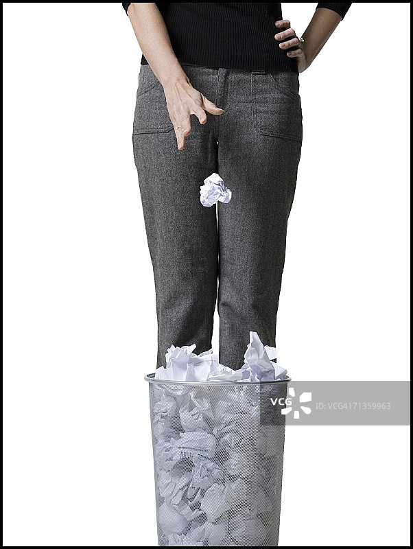 一个女人把纸扔进废纸篓的中段视图图片素材