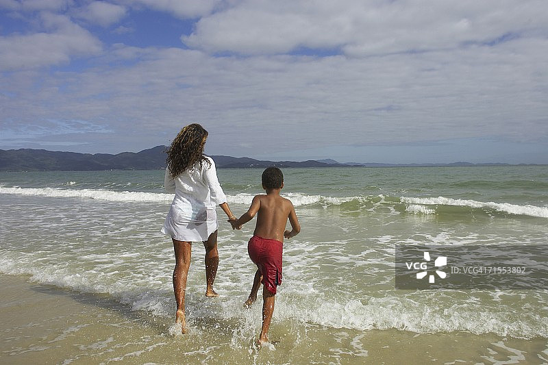 非洲母亲和儿子在巴西弗洛里亚诺波利斯冲浪图片素材