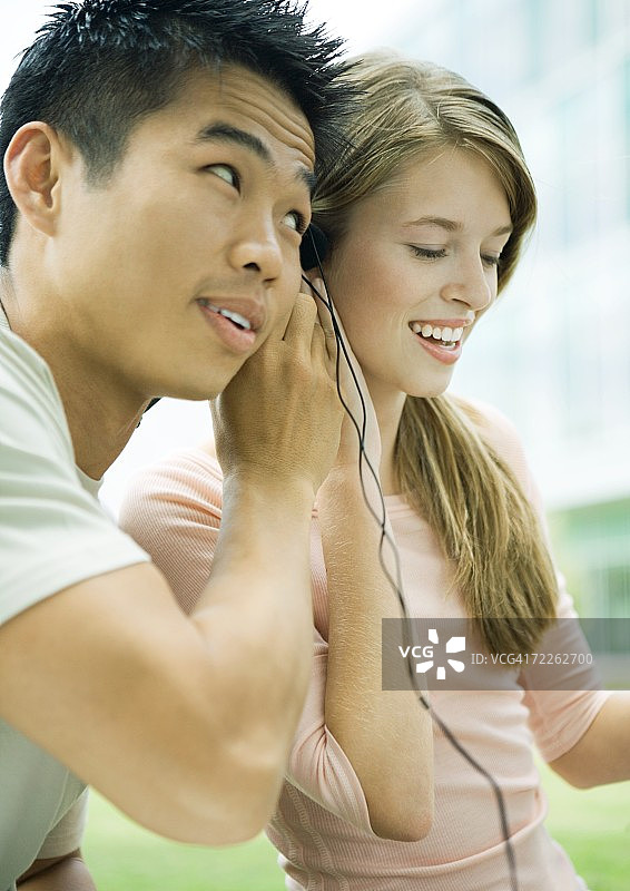 年轻男女共用耳机图片素材