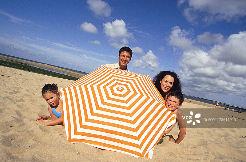 一家人在海滩撑伞图片素材