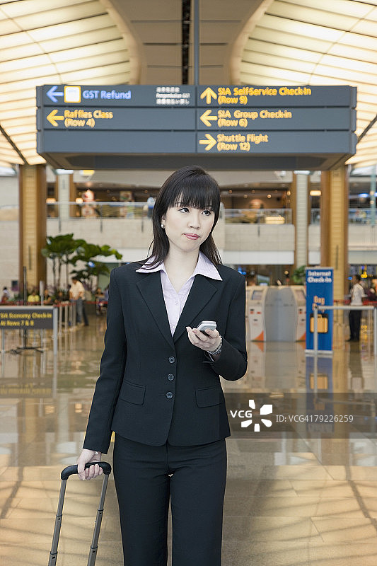 女商人拿着手机离开机场图片素材