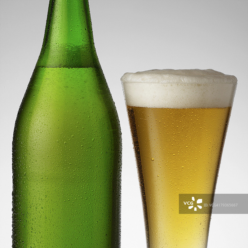 室内满杯啤酒，旁边是一瓶啤酒图片素材