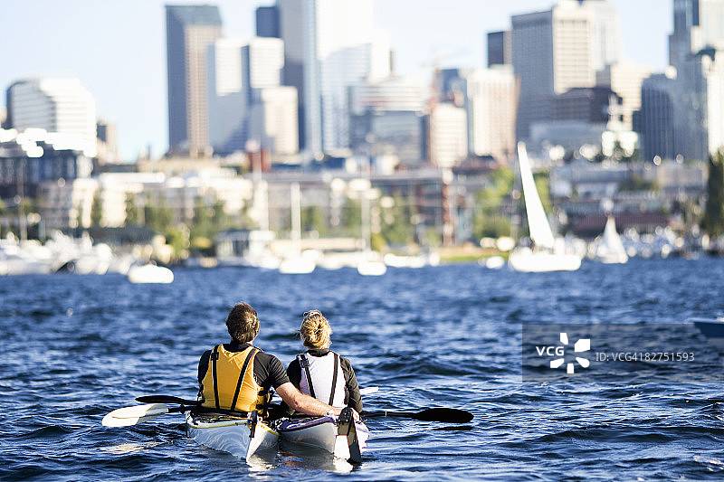 20多岁的科克夫妇在城市湖上划皮艇图片素材