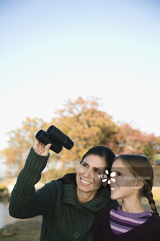 一位中年妇女和她的女儿用望远镜看东西图片素材