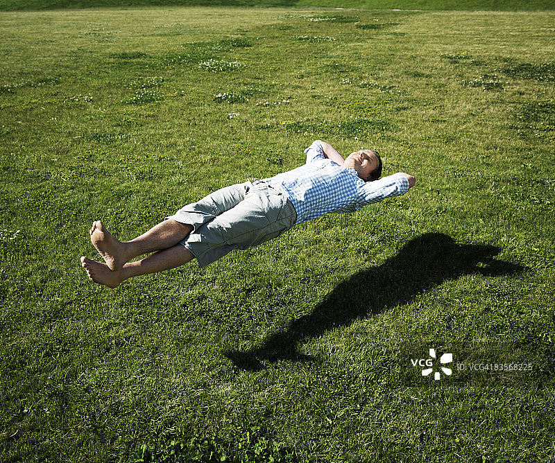 人放松漂浮在草地上图片素材