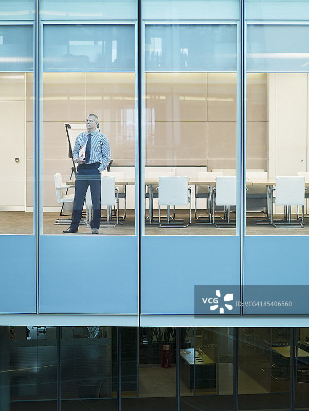一个商人站在会议室的窗口图片素材
