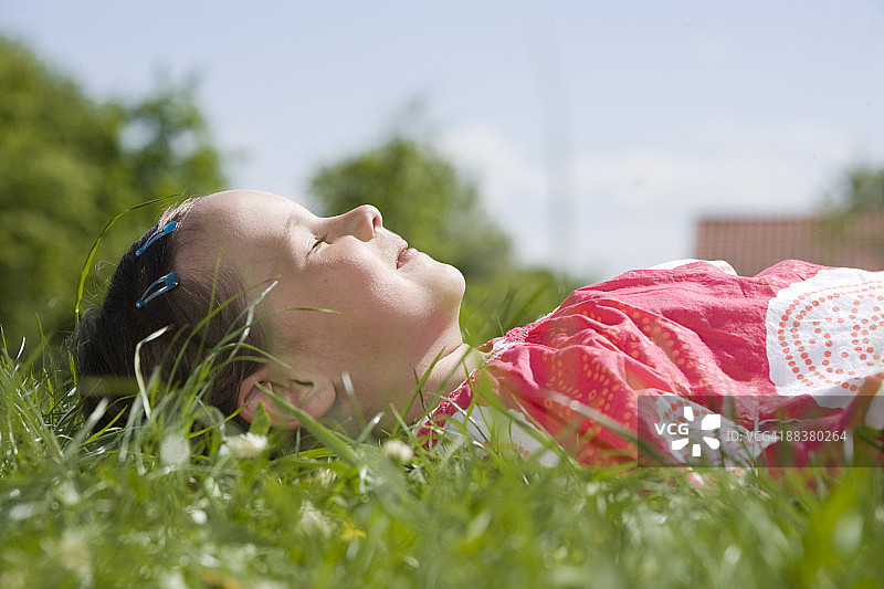 女孩在草地上休息，侧视图，特写图片素材