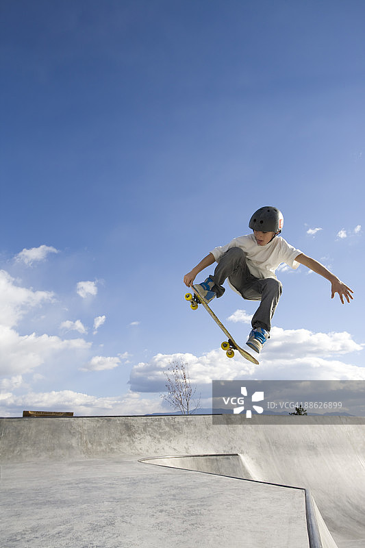 一只年轻的雄性在滑板公园呼吸新鲜空气。图片素材