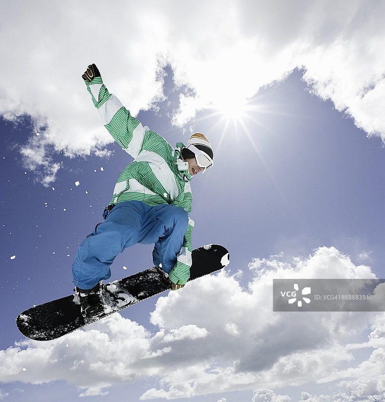 男子滑雪板在空中跳跃图片素材