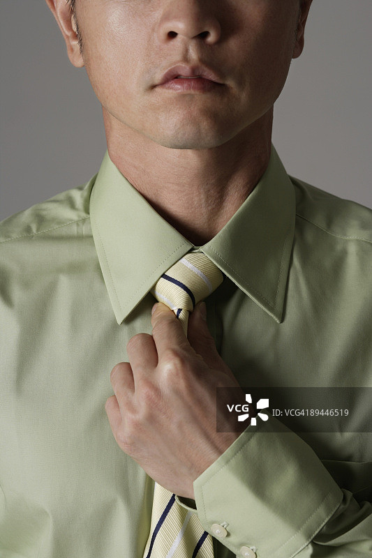 男人收紧领带的Crop肖像图片素材