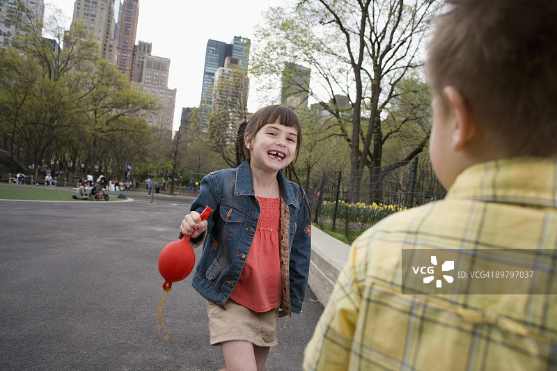 纽约市中央公园，一个小女孩拿着一个气球图片素材