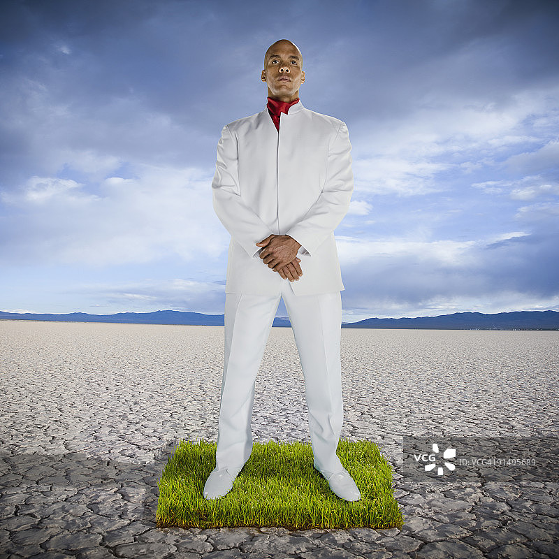 一个非洲人站在沙漠中的一片草地上图片素材