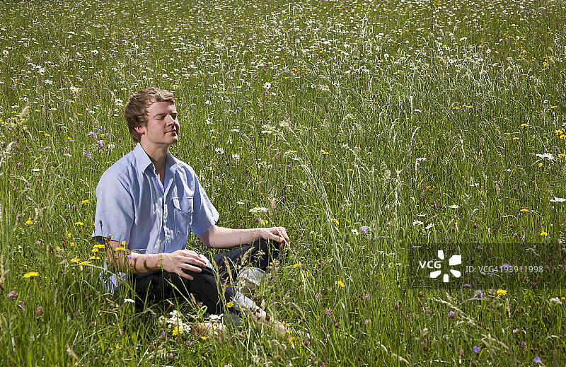 人坐在草地上，春暖花开图片素材