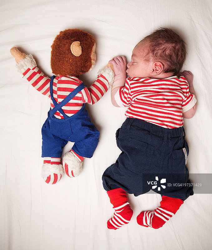 一个新生儿和他的泰迪熊图片素材