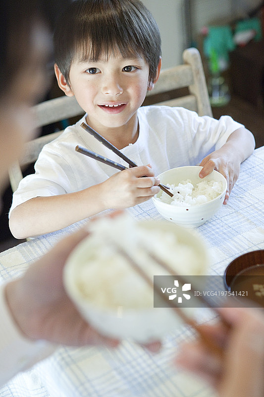 男孩(4-5)用筷子吃米饭图片素材
