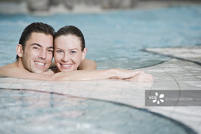 一对年轻夫妇在游泳池里的肖像图片素材
