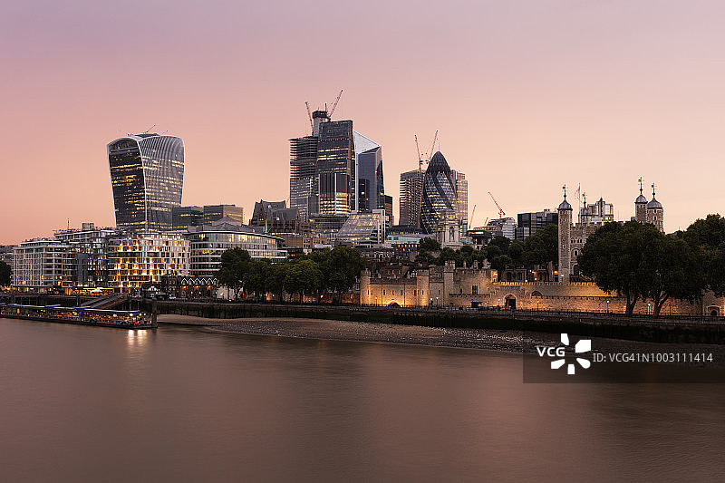 黄昏时分的河岸，照亮了伦敦城市的天际线图片素材