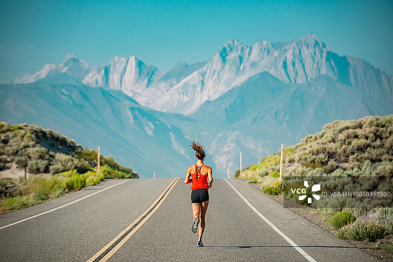 精英女子运动员在加州塞拉山脉的一条路上奔跑图片素材