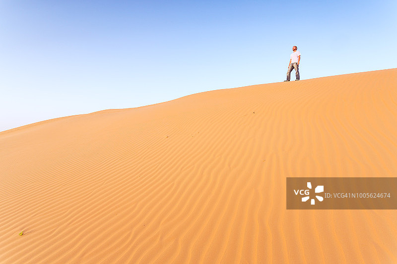 阿布扎比沙漠沙丘上的孤独男子图片素材