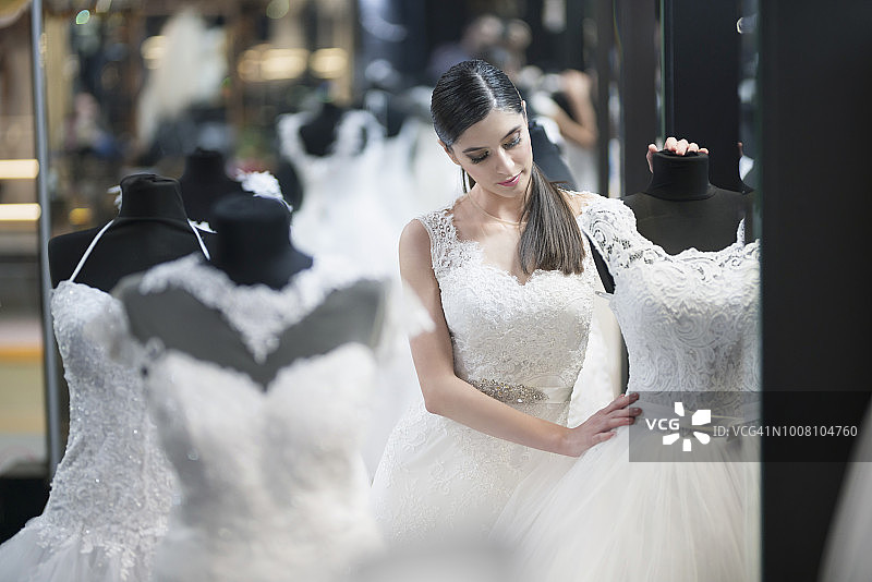 年轻美丽的新娘在寻找婚纱图片素材