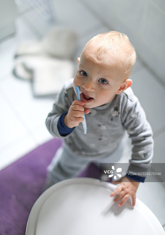 一个小男孩在学习如何刷牙。图片素材