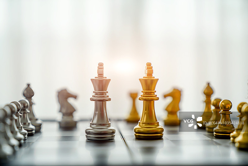 金王在棋局中面对另一支银队，以白色为背景。公司战略、商业胜利或决策的概念图片素材