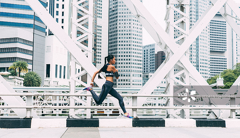 亚洲女运动员在城市里跑步图片素材