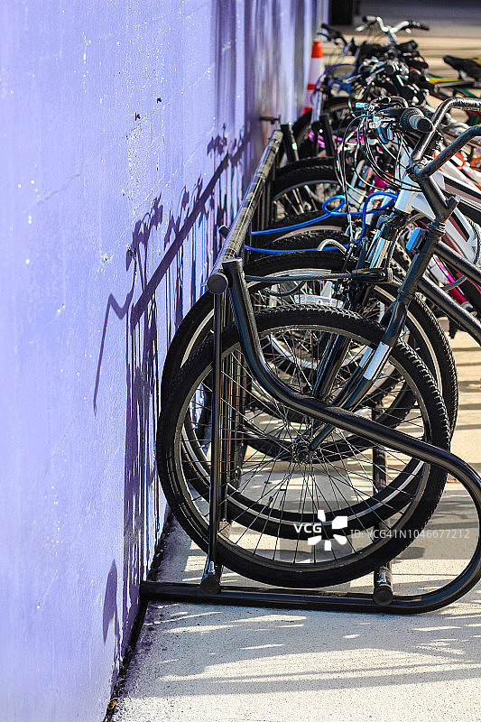 自行车架靠在紫色的墙上图片素材