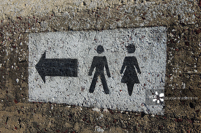 水泥墙上绘有男女厕所方向标志图片素材