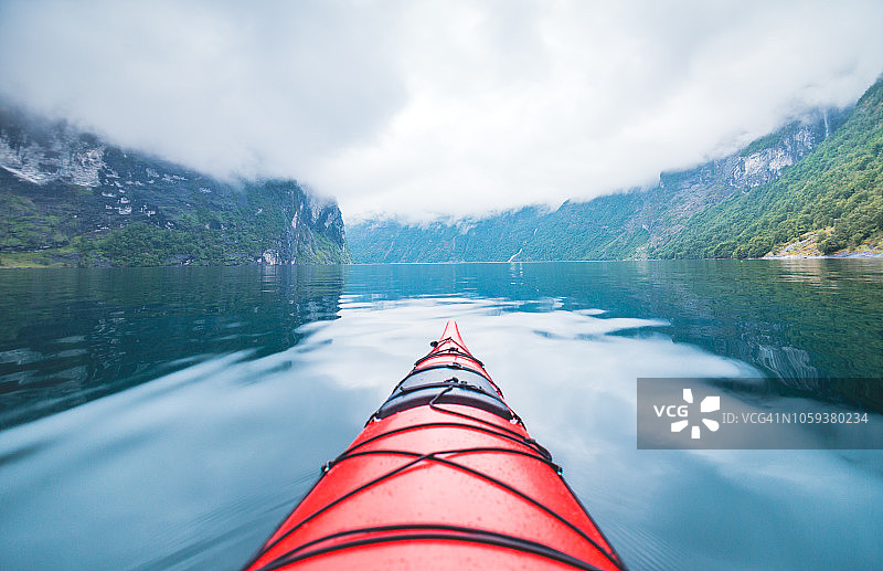 划独木舟穿过挪威峡湾。图片素材