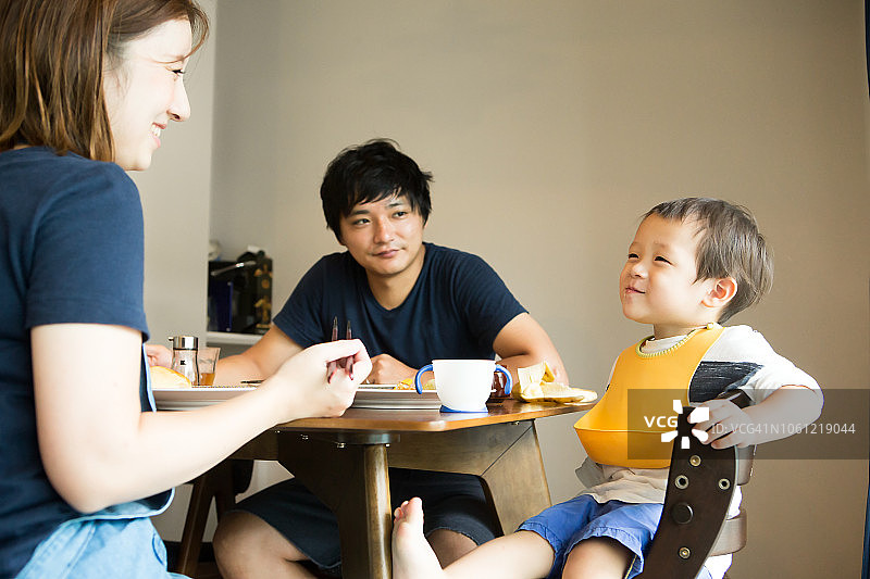 吃早餐时微笑着说话的家庭图片素材