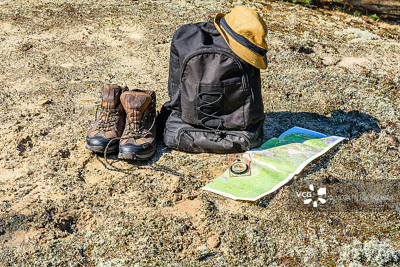 背包，旅游靴，地图，指南针和帽子放在地上图片素材