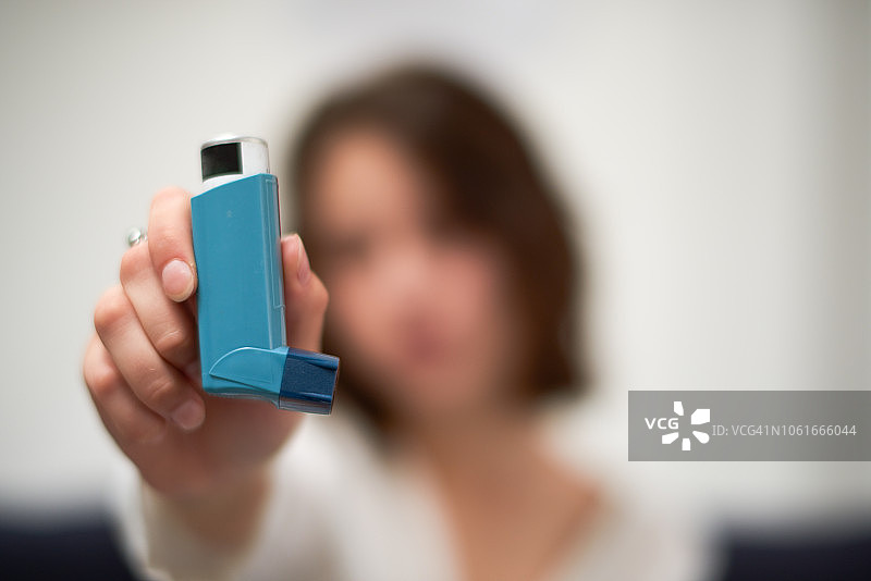 年轻女子使用哮喘吸入器图片素材