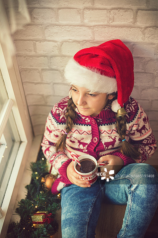 美丽的小女孩在温馨的圣诞气氛中喝着热巧克力图片素材