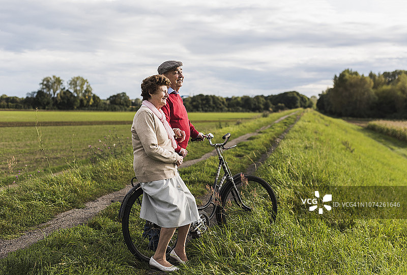 在乡村景观中骑着自行车的老年夫妇图片素材