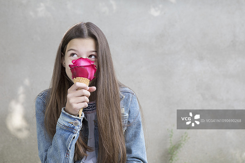 女孩闻着冰淇淋里粉红色的玫瑰花图片素材