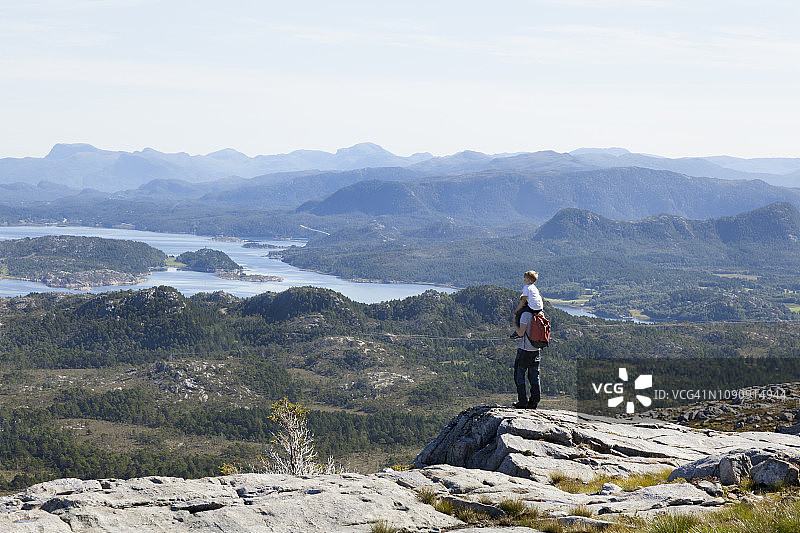 挪威莫尔奥格罗姆斯达尔的奥雷，男孩和父亲从岩层上望向入口景观图片素材