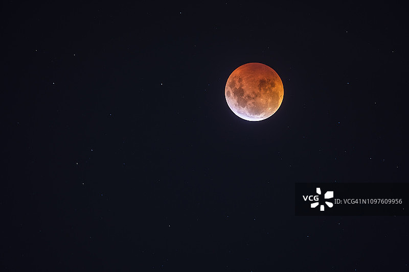 来自智利圣地亚哥的红色满月月食，这是一个从南半球看到的地球阴影穿过月球表面并将其变成红色和黄色的惊人天文事件图片素材