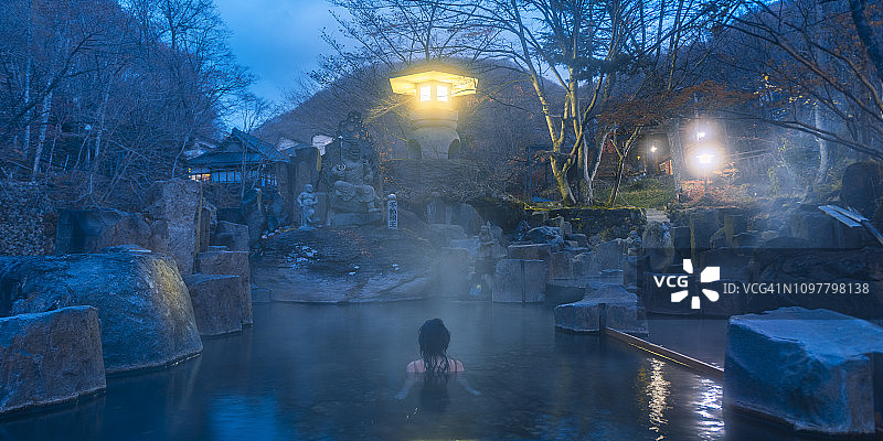 黎明时分，一名女子在日本温泉中放松。图片素材