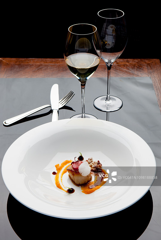 法式鲜扇贝在精致餐桌上烹饪图片素材