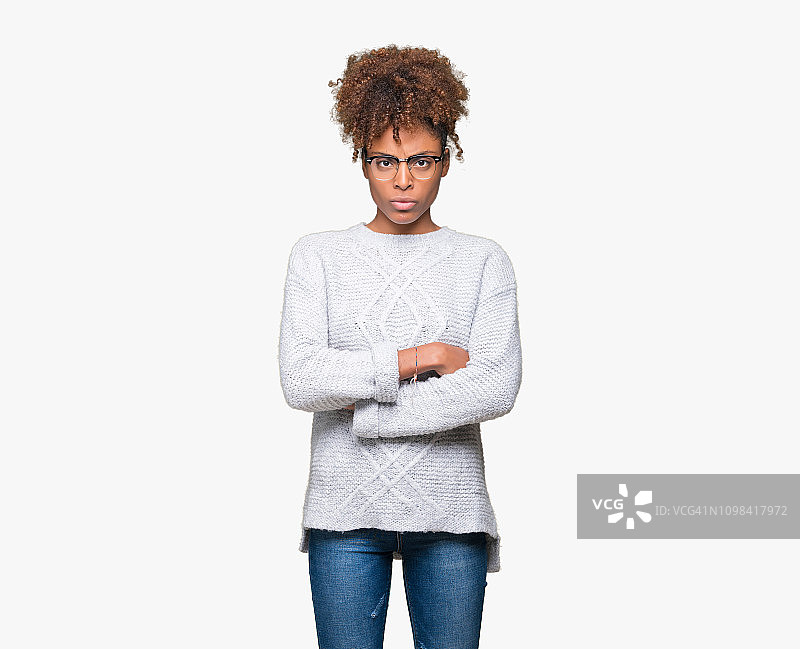 美丽的年轻非洲裔美国女人穿着冬季毛衣在孤立的背景怀疑和紧张，不赞成的表情在脸上与交叉的双臂。消极的人。图片素材